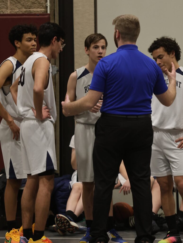 Royalmont high school basketball players listening to their coach during a timeout